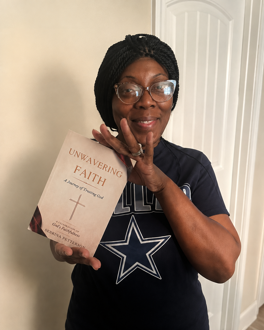 Sebrina Petterson at home holding a copy of Unwavering Faith when the first 25 books were delivered