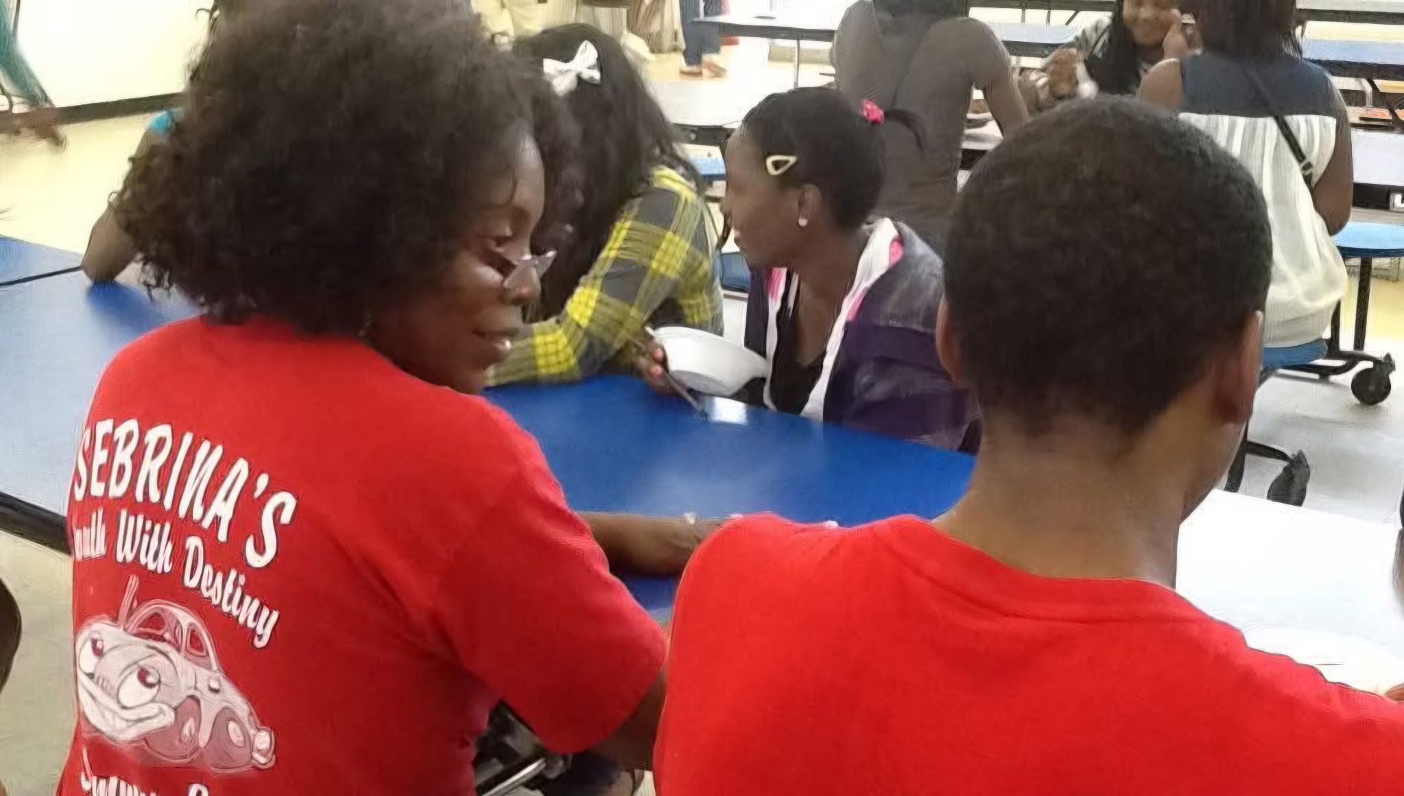Sebrina Petterson wearing a Sebrina's Youth With Destiny shirt, interacting with kids at a community event